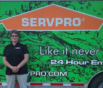 Photo of SERVPRO of Spencer & Iowa Great Lakes Production Crew Member Dianna Reed standing next to company trailer.